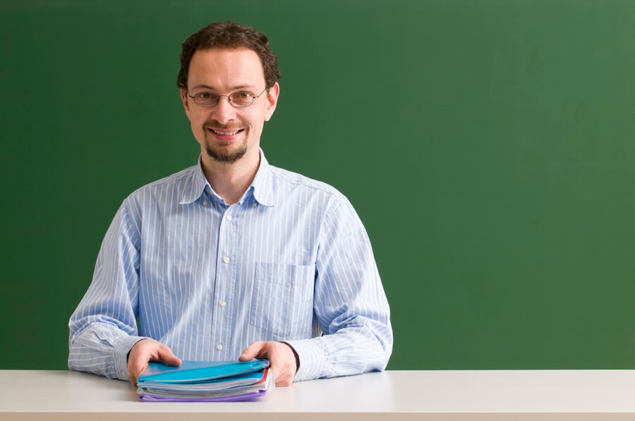 teacher sitting at blackboard